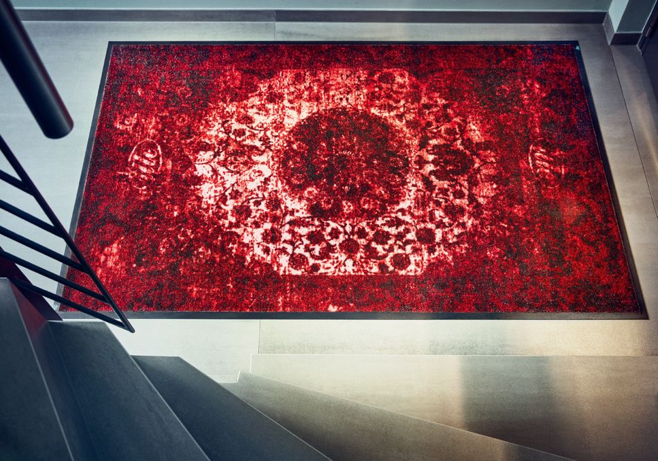 Darstellung des Teppichs Persiano Rosso, der am unteren Ende einer Treppe liegt
